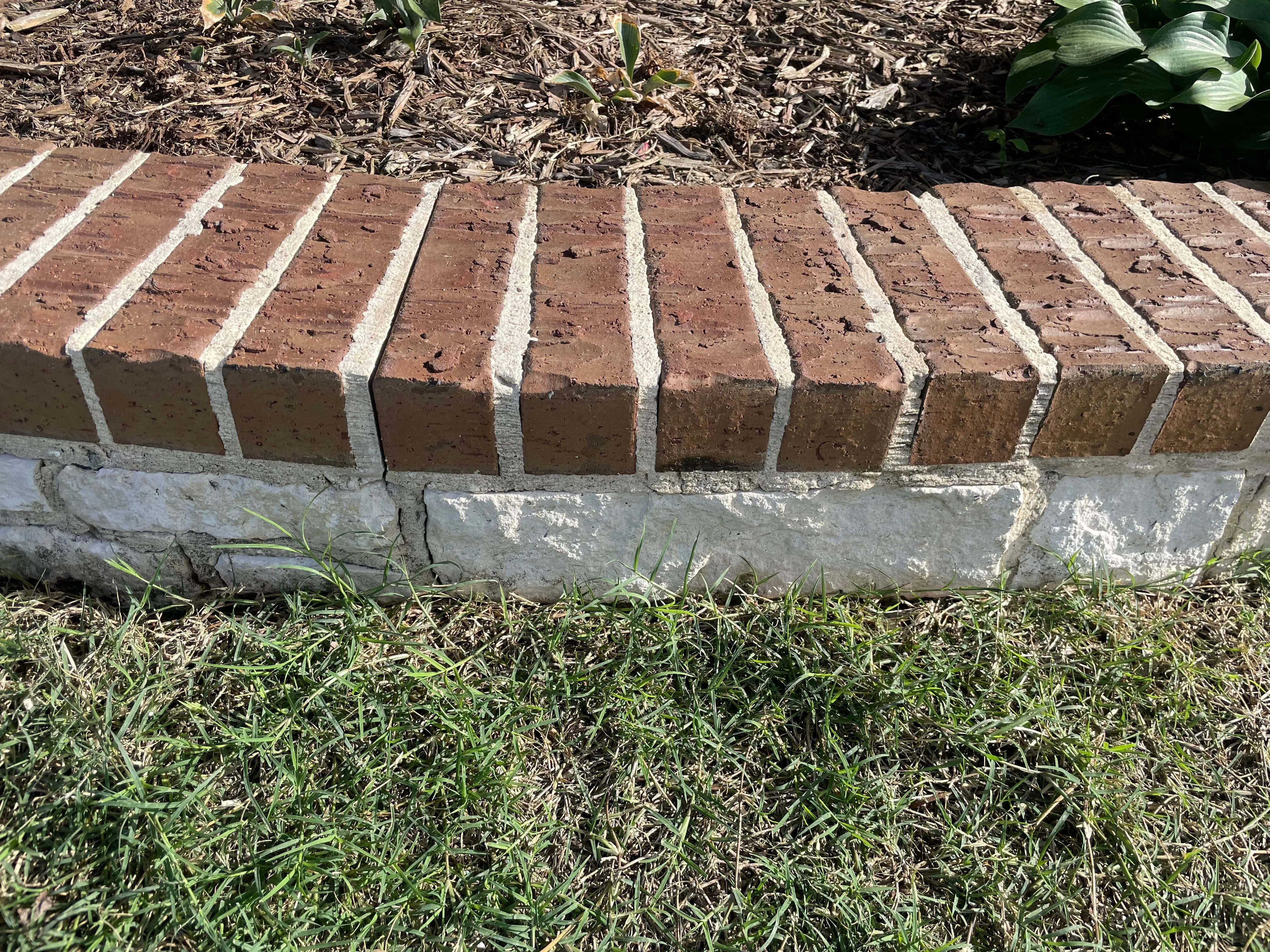 Brick garden edging with a bright, clean white base after power washing in Wylie, TX