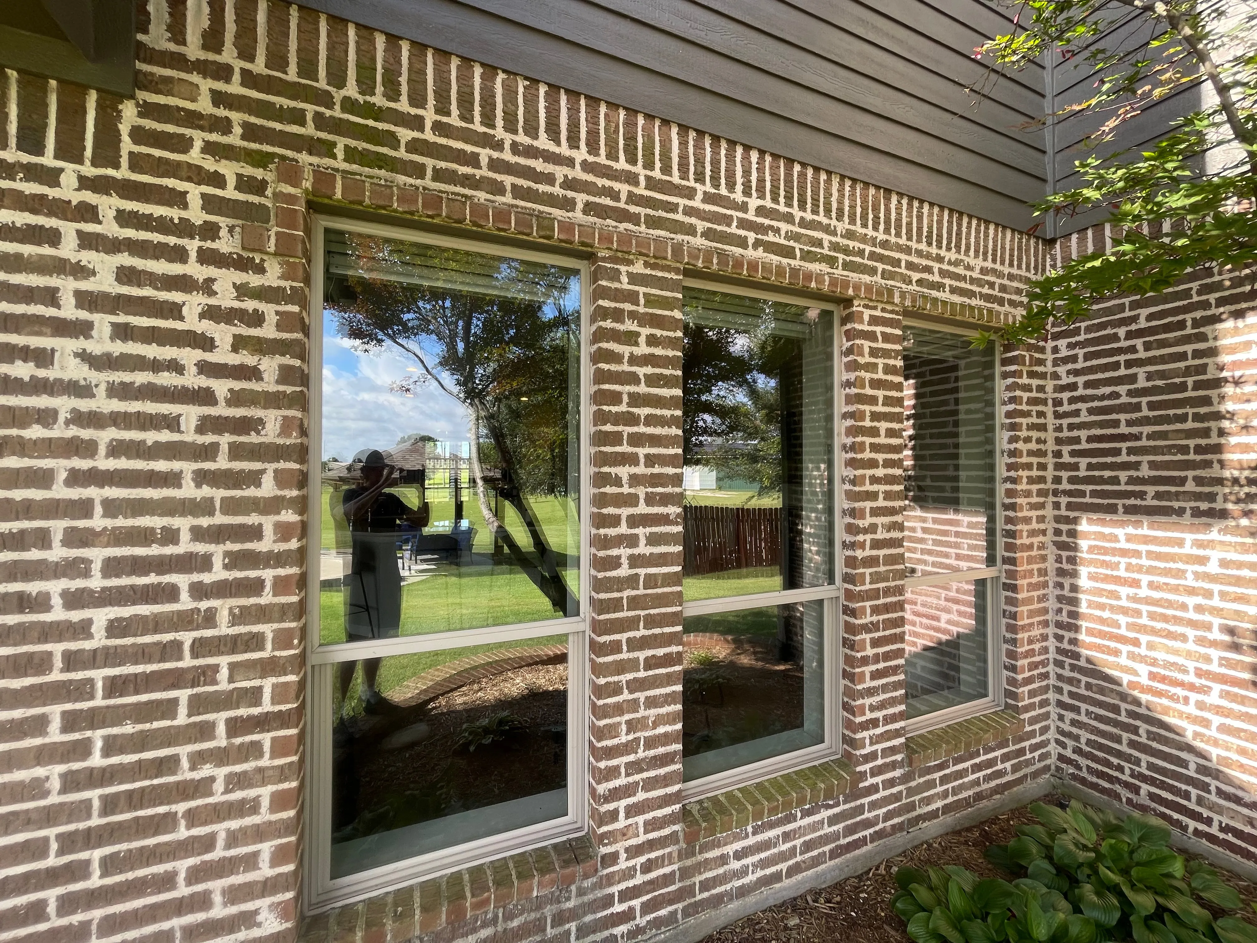 Brick exterior wall with windows and grimy mortar before cleaning in Wylie, TX