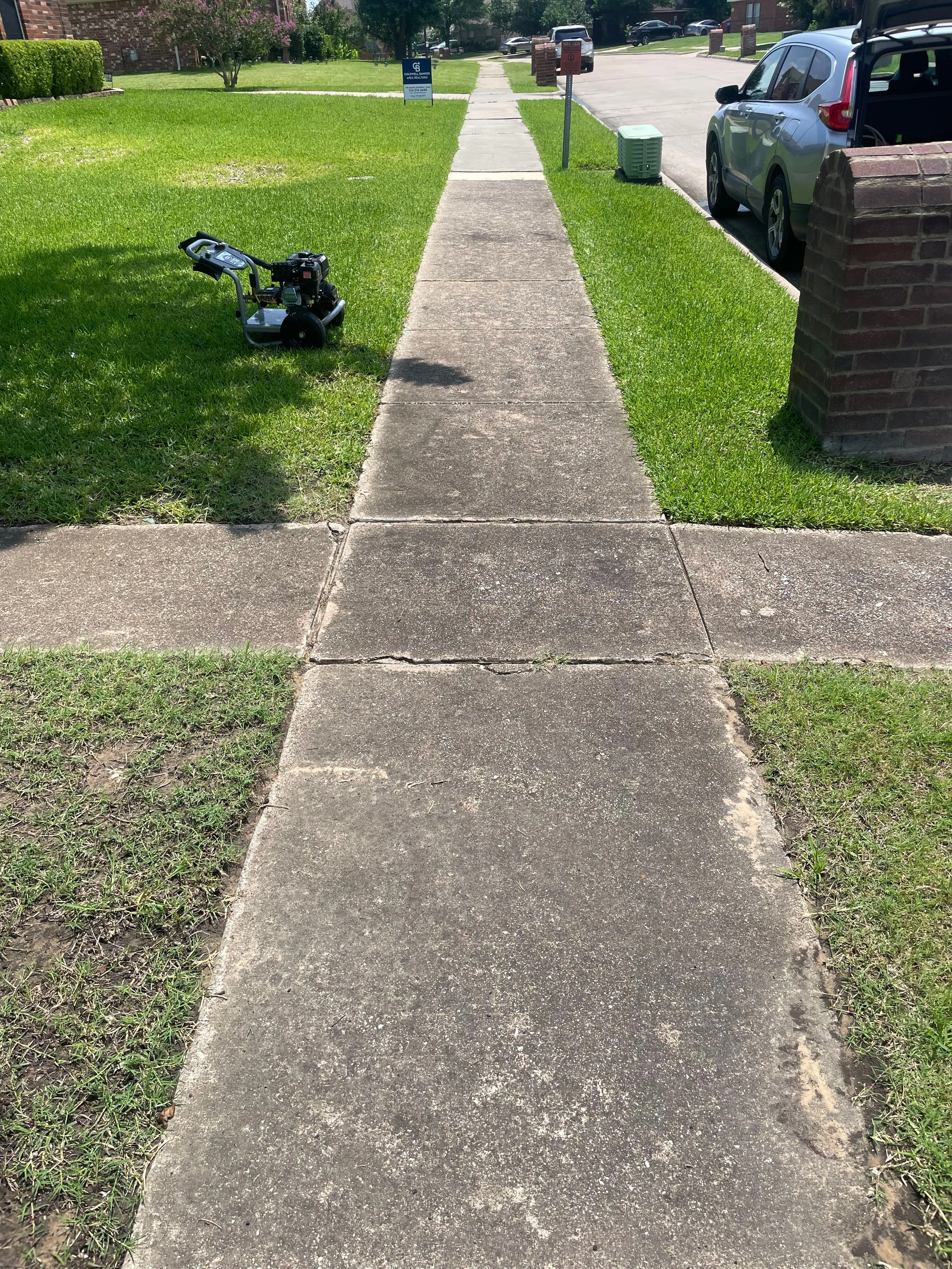 Dirty, stained sidewalk leading to the street before pressure washing in the Dallas area